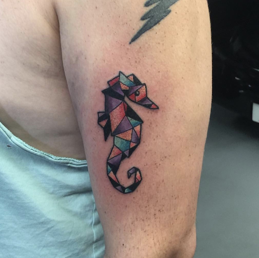 Geometric seahorse tattoo on front of arm