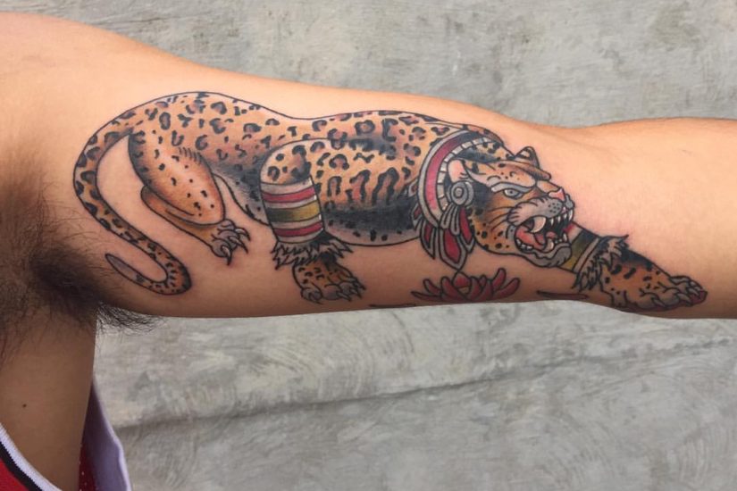 Tattoo of a colorful jaguar on an inner arm