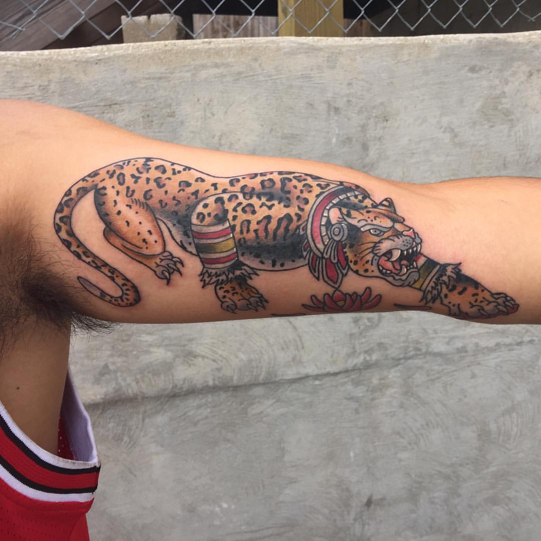 Tattoo of a colorful jaguar on an inner arm